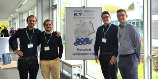 Vier Mitarbeiter des LKP stehen vor einem Plakat